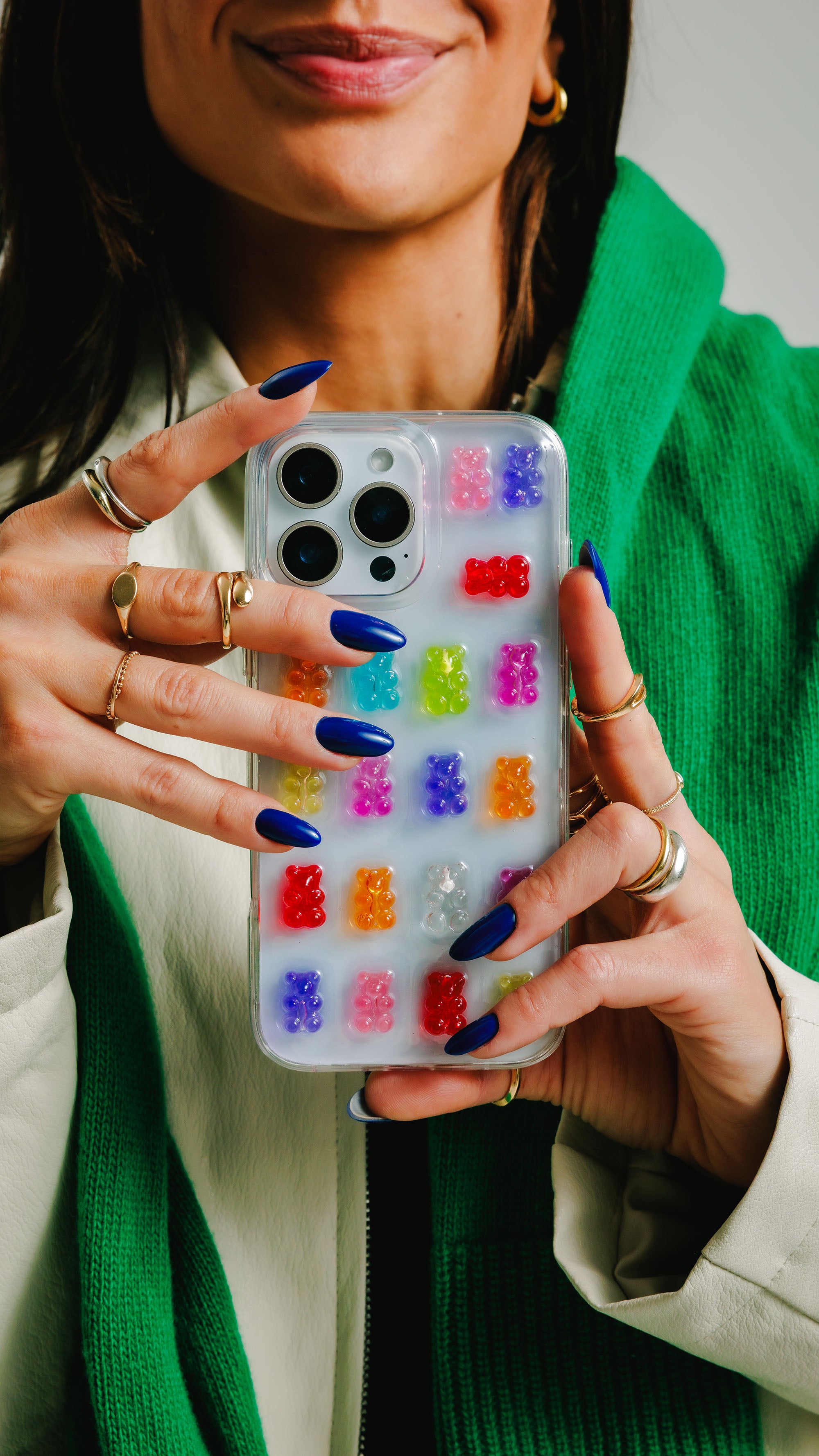 Person holding a phone with a colorful gummy bear case