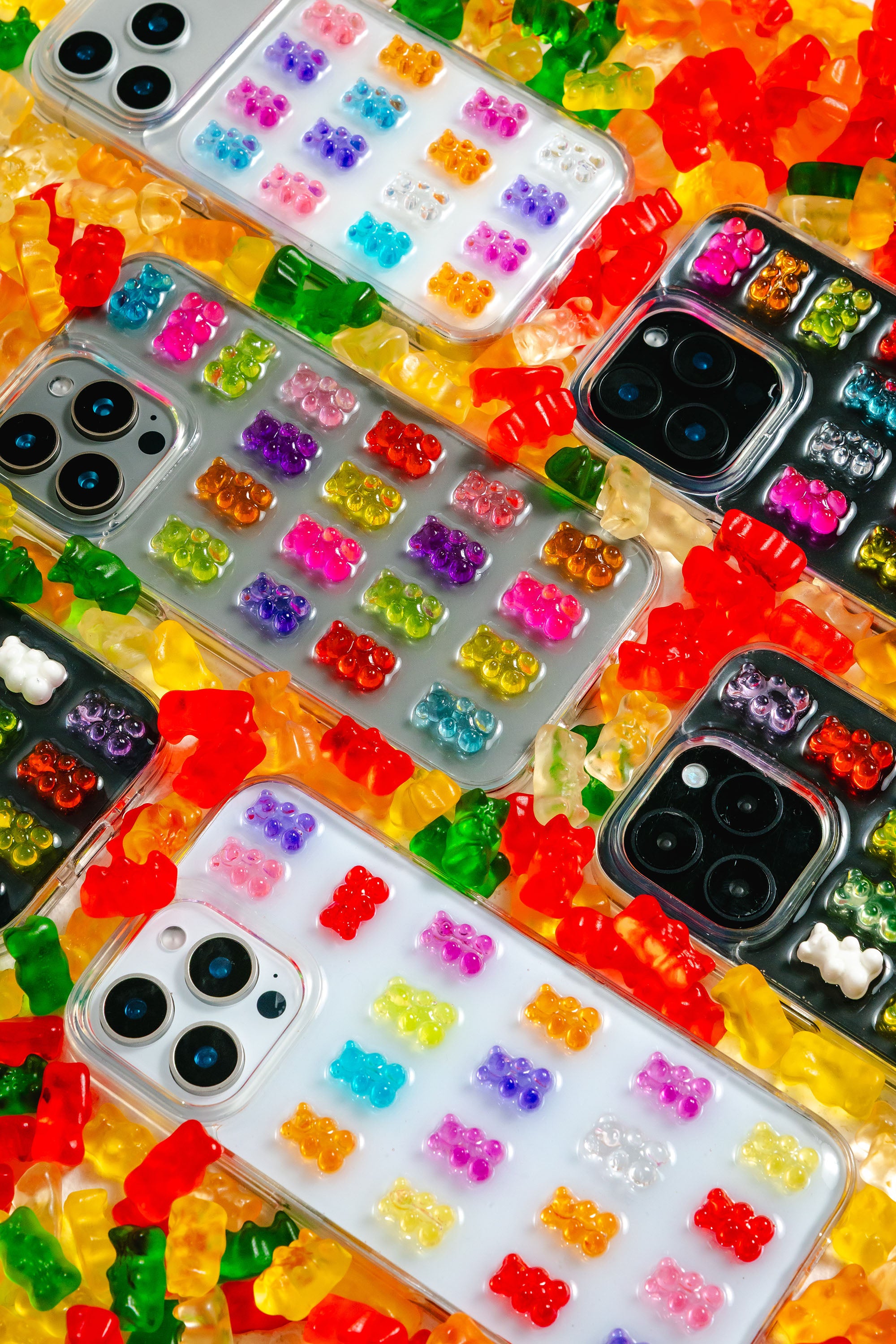 Colorful phone cases with gummy bear design on a bed of gummy bears