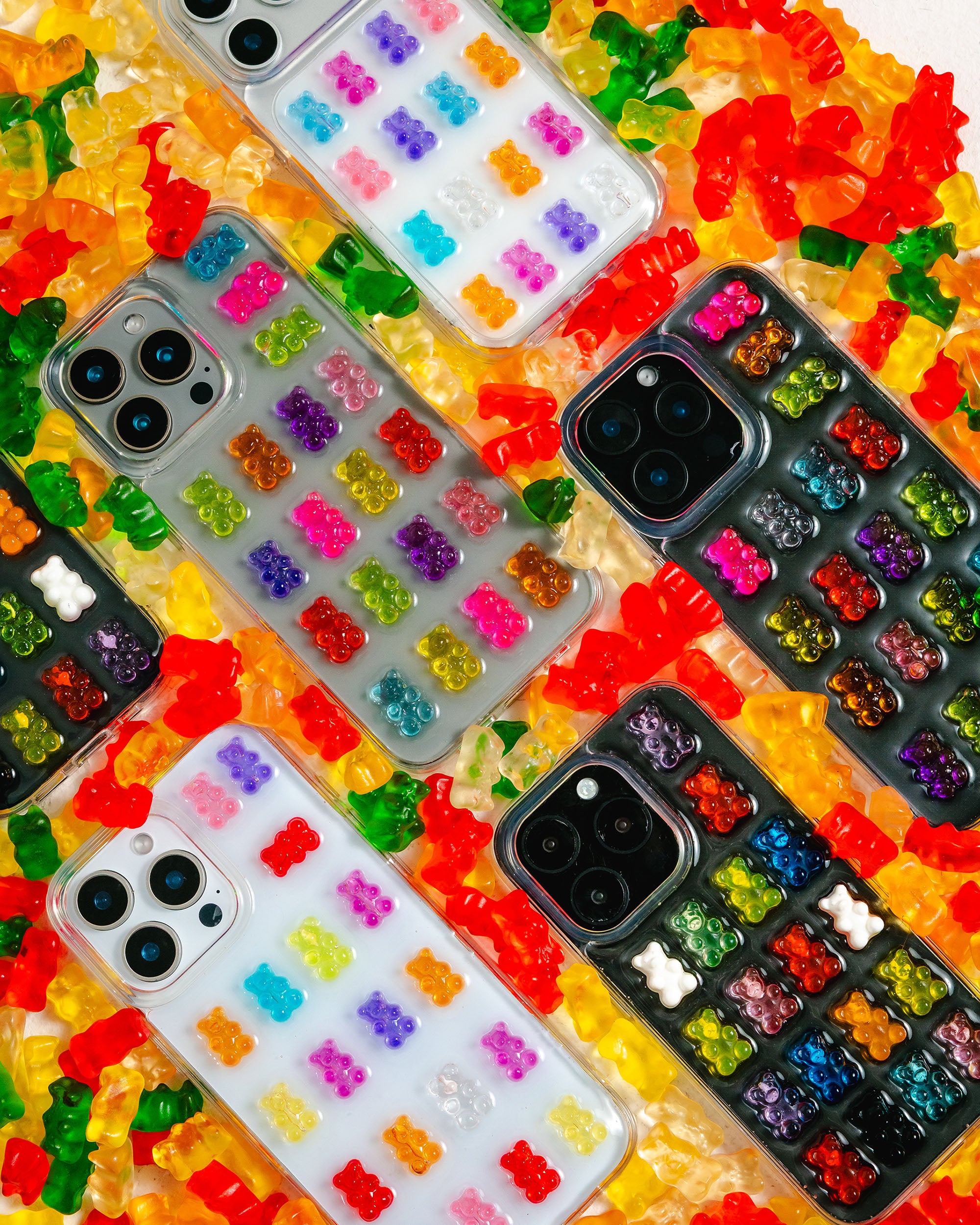 Colorful phone cases with gummy bear design on a bed of gummy bears